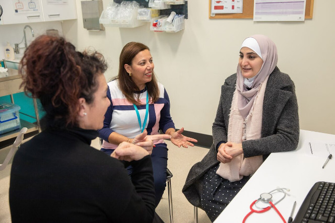 Woman talking to clinician through an interpreter