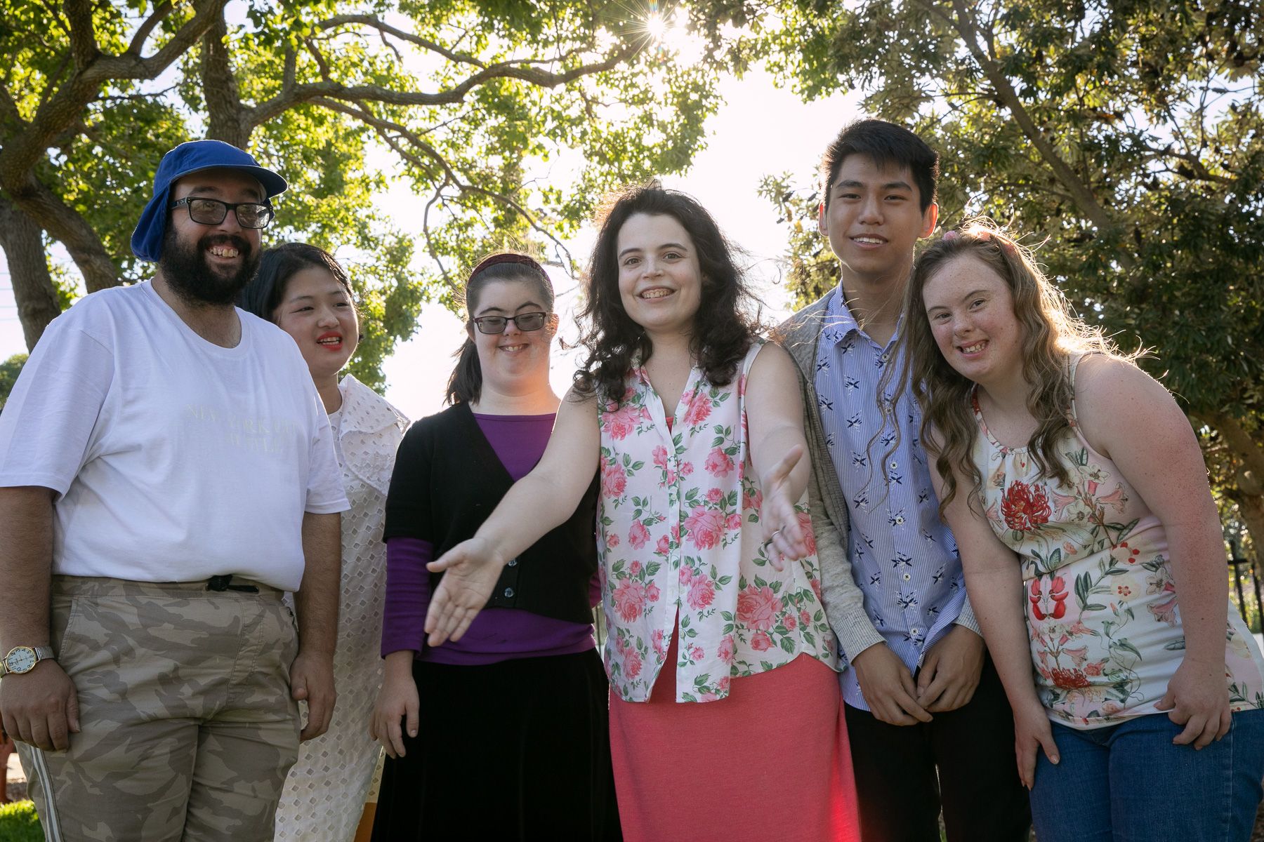 A group of young people with intellectual disability stand in the sunshine