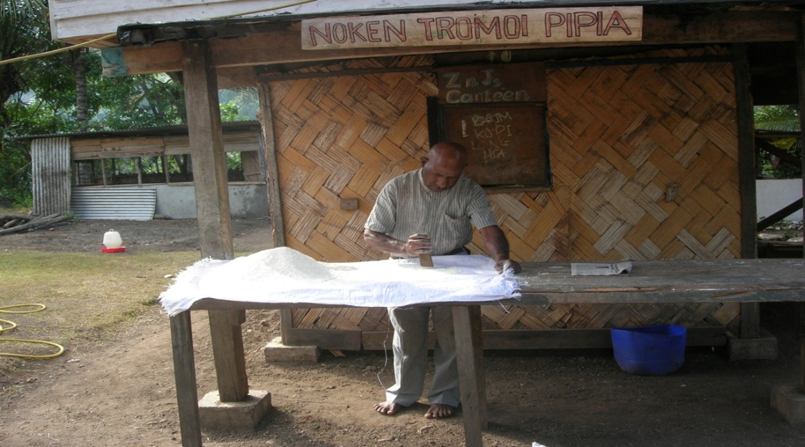 Man pounding wheat