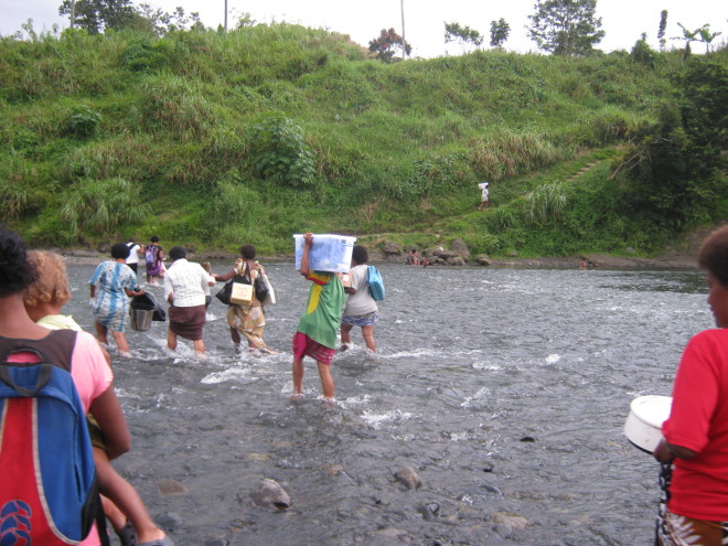 Trainers crossing a creek